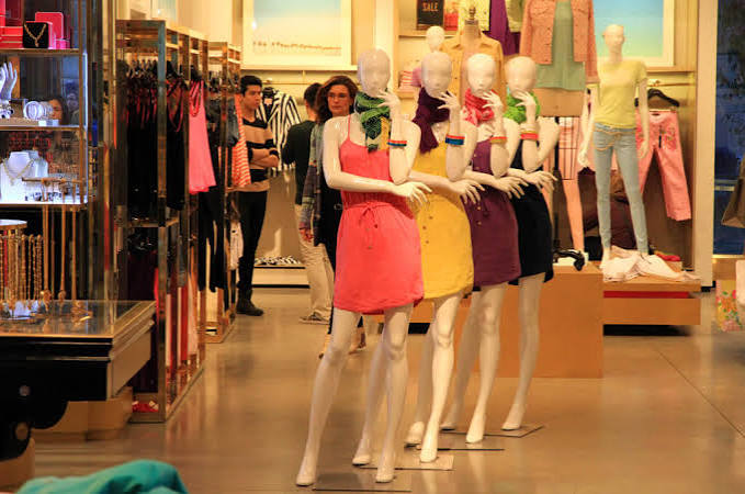 Vitrine de loja com manequins e looks coloridos